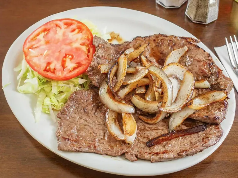 Grilled steak with onions and salad at La Caridad 72, a Asian Restaurant in New York