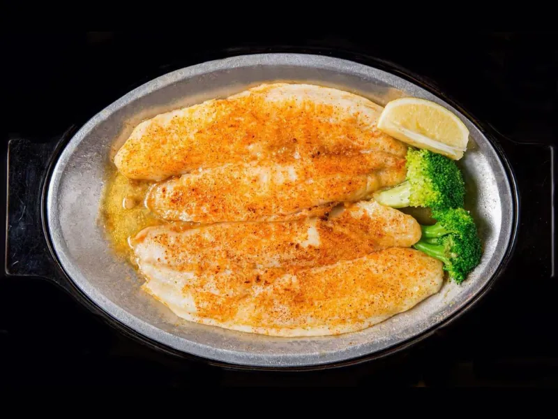 Seasoned grilled fish with broccoli at La Caridad 72, a Asian Restaurant in New York